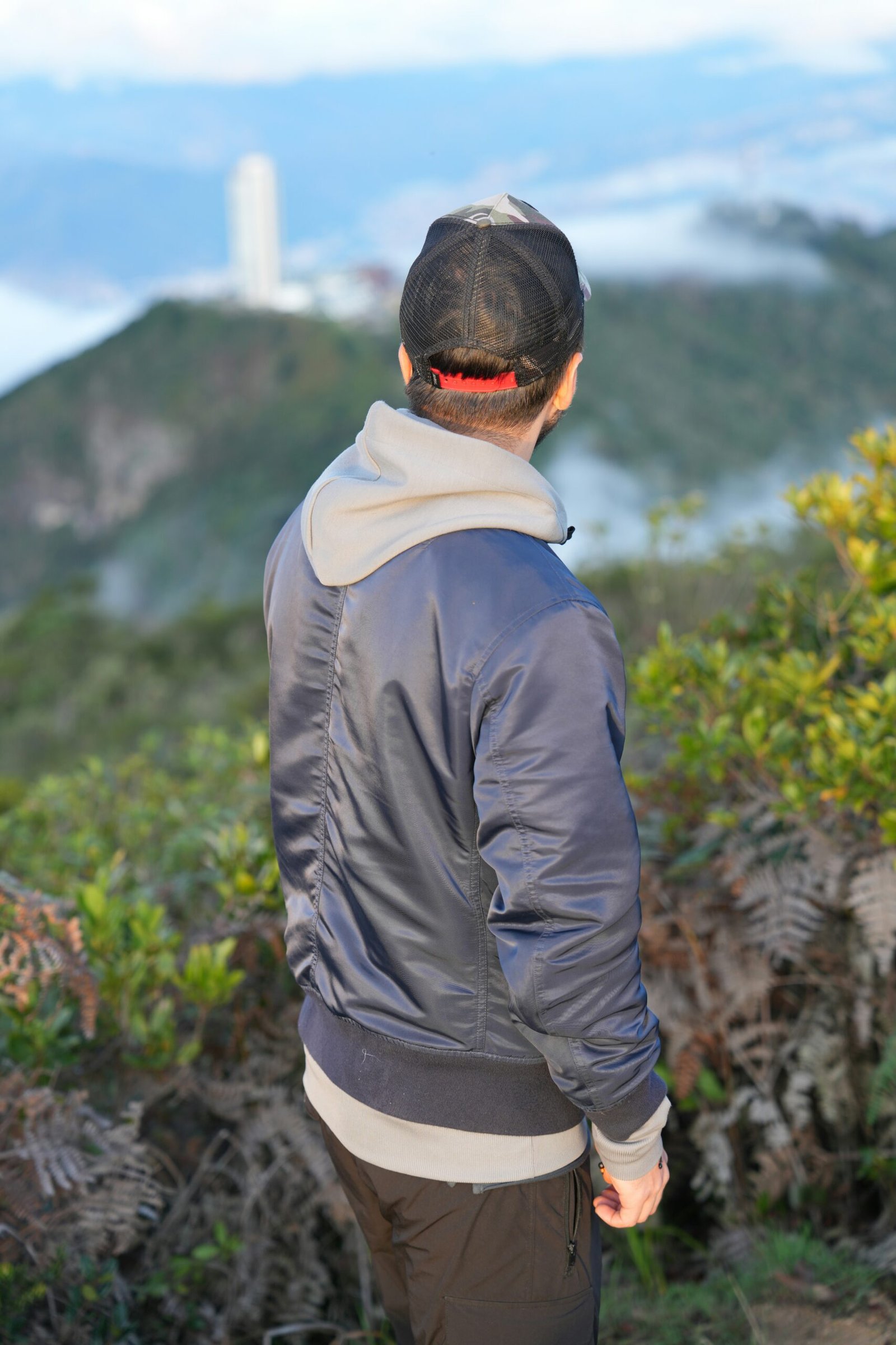 a man standing on top of a lush green hillside