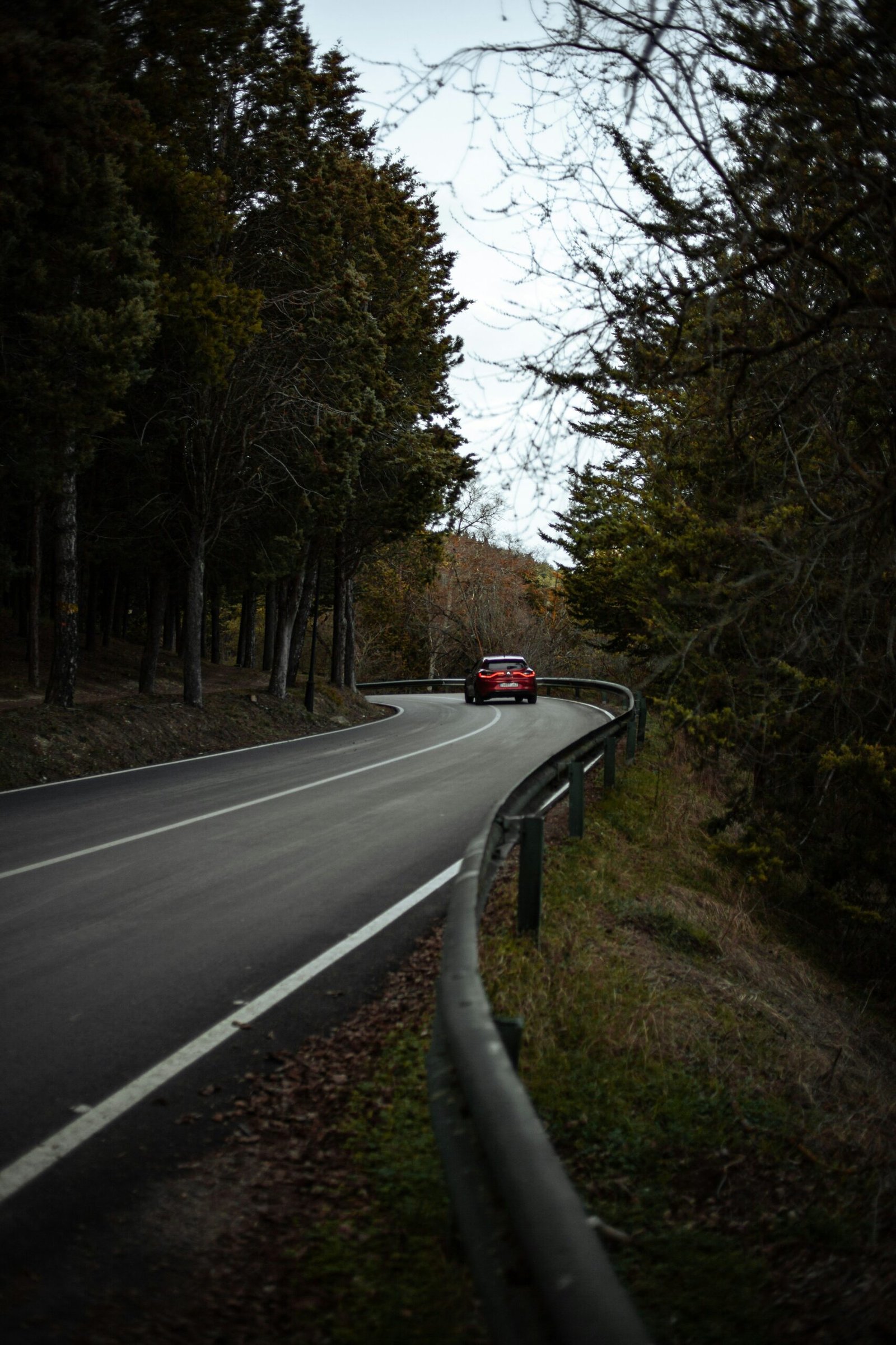 a red car driving down a curvy road