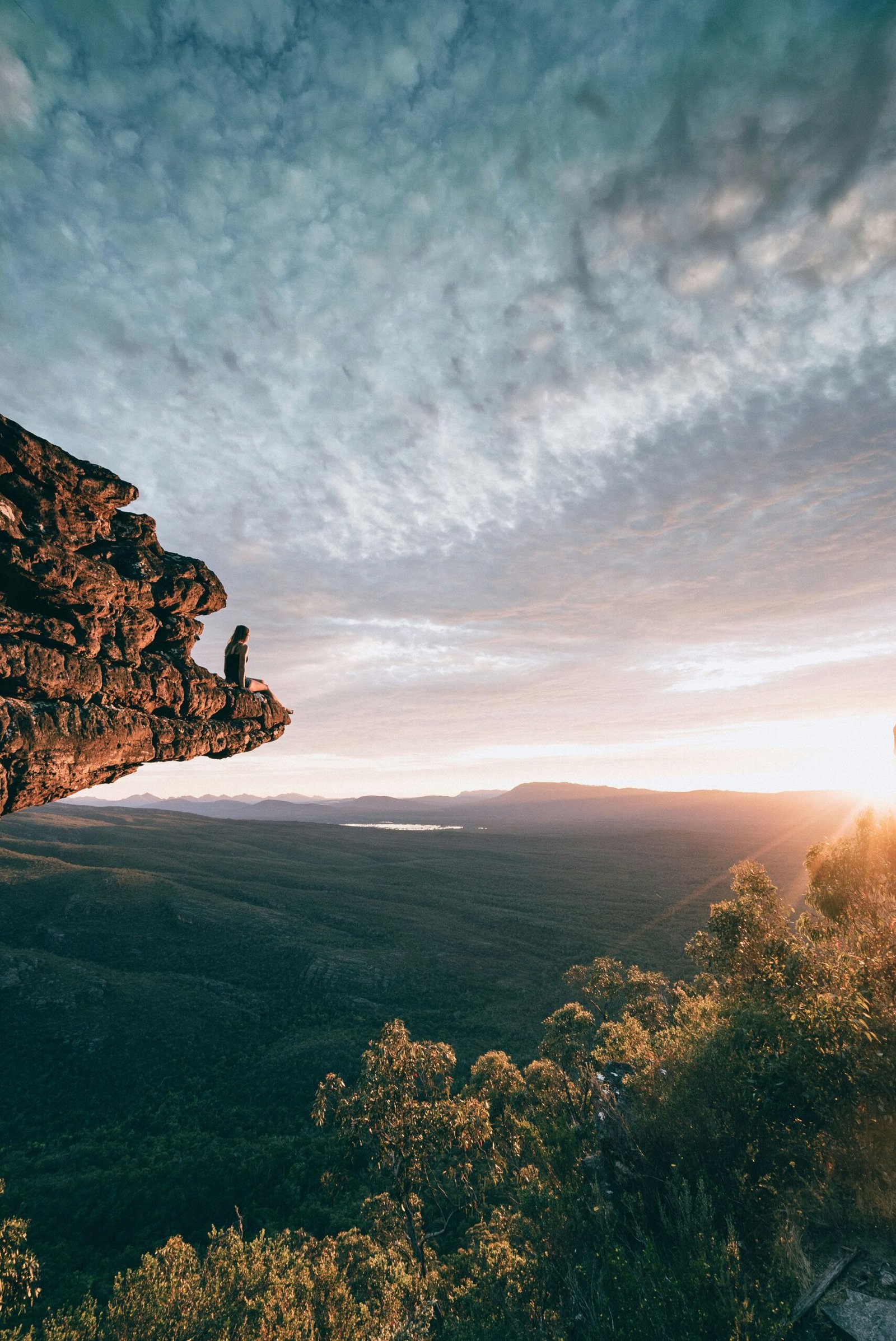 man sitting on mountain rock